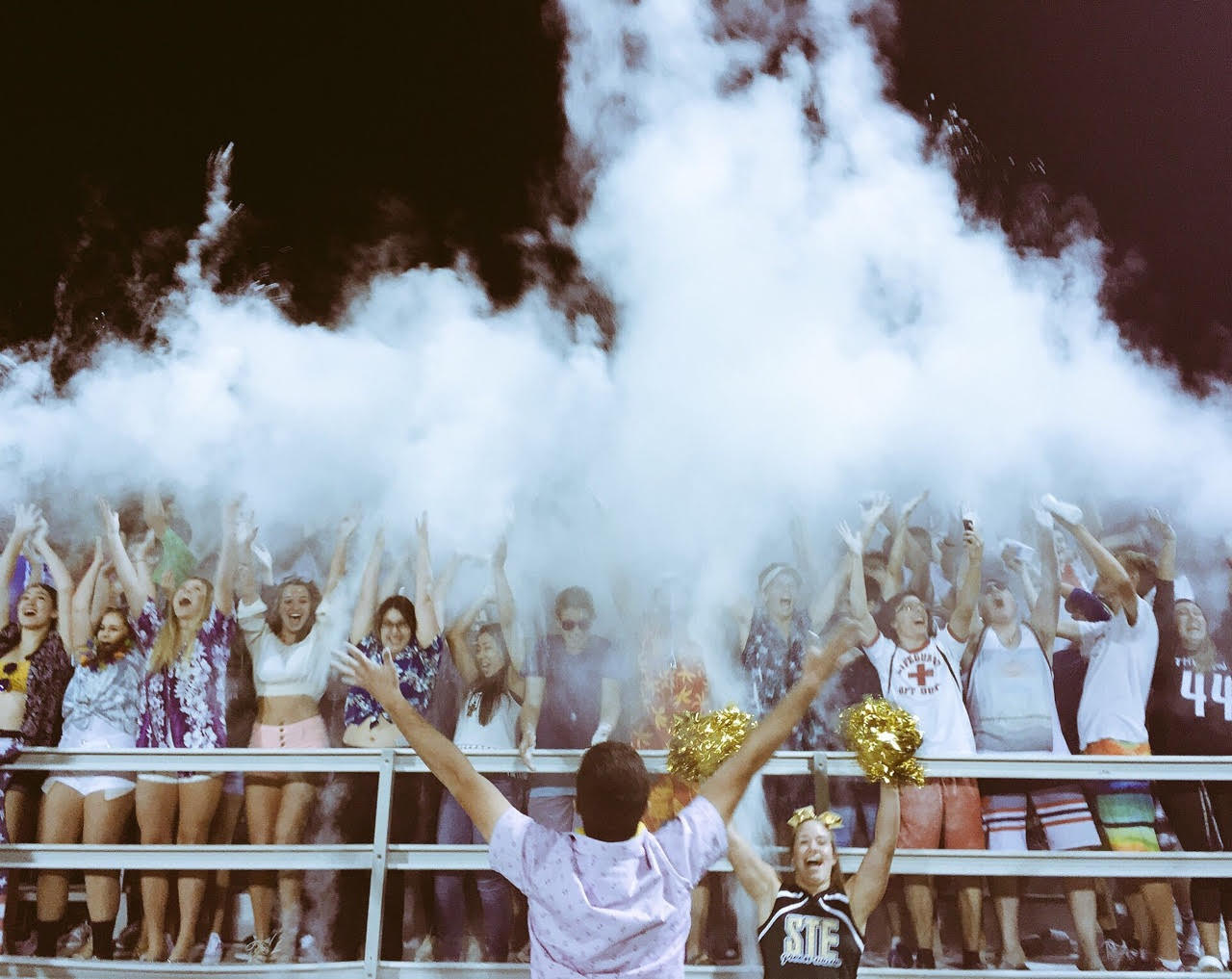 Green machine student section throwing up baby powder in celebration at the first football game.