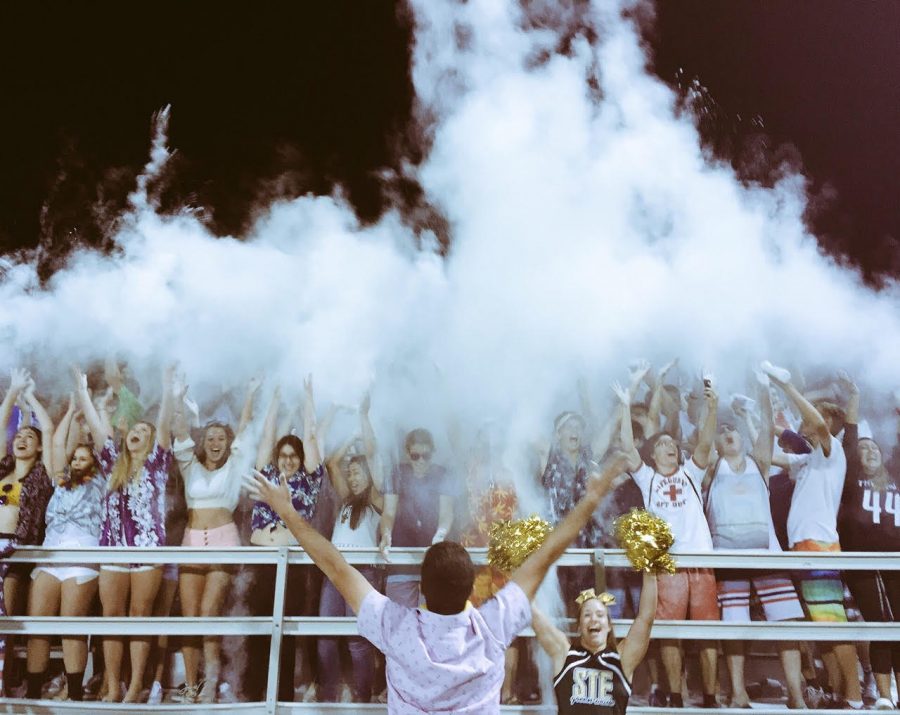Green machine student section throwing up baby powder in celebration at the first football game.
