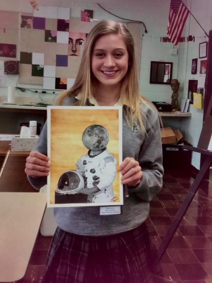 Senior Katie Ellsworth holding one of her art pieces about the moon landing.