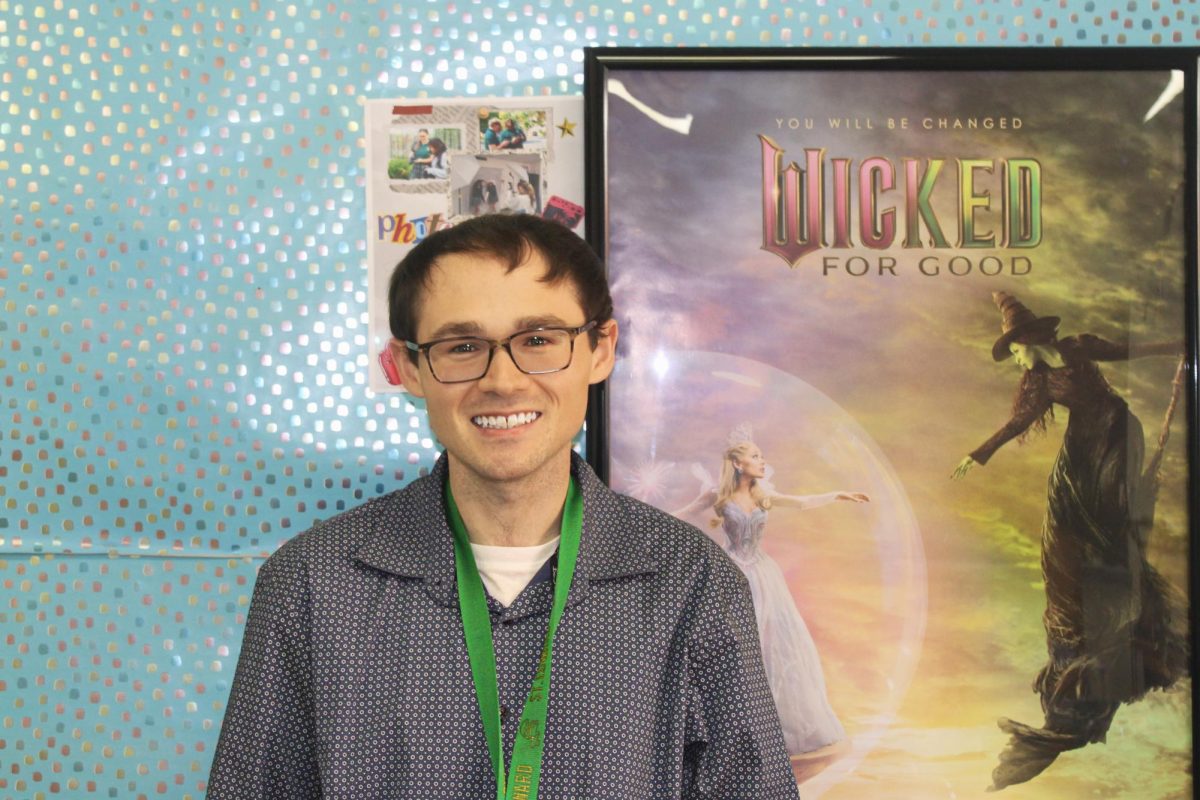Mr. Hickey poses next to the "Wicked: For Good" poster.